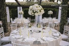 the table is set with white flowers and place settings for an elegant wedding reception at the resort