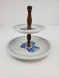 two plates with blue and white designs on them, one is holding a wooden handle