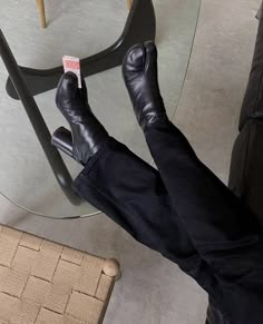 a person laying on the floor with their feet propped up in front of a glass table