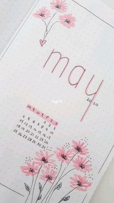 an open notebook with pink flowers and the word may written in cursive writing