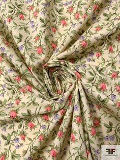 the fabric has pink flowers and green leaves on it