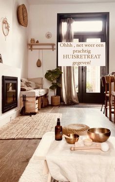 a living room filled with furniture and a fire place in front of a window on top of a rug