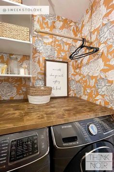 a washer and dryer in a small room with floral wallpaper on the walls