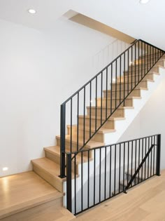 there is a stair case next to the stairs in this house with wood floors and white walls