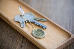 two keys are sitting on a wooden tray