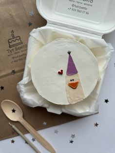 a paper plate with a bird wearing a party hat on it next to a spoon and fork