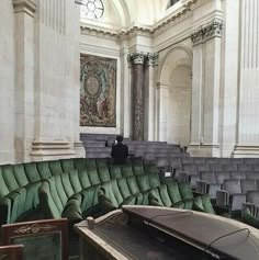 an empty room filled with lots of green couches