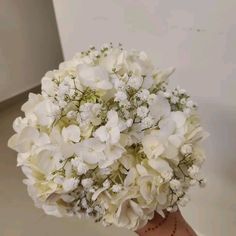 a bouquet of white flowers in someone's hand