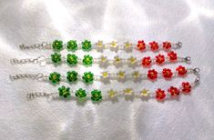 four pieces of beaded jewelry on a white cloth with beads in the shape of flowers