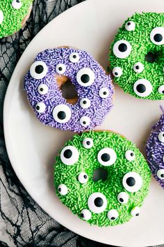 decorated donuts with googly eyes and sprinkles on a white plate