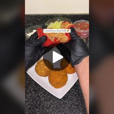 a person in black gloves is preparing food on a white plate with red peppers and lettuce