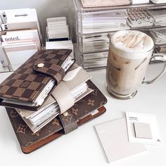 there is a cup of coffee on the table next to some papers and other items