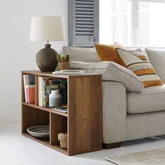 a living room with a couch, coffee table and bookshelf in front of the window