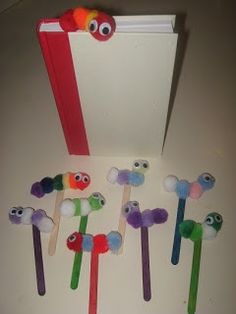 several colorful toothbrushes with faces on them in front of an open book,