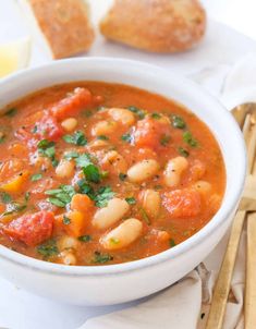 a white bowl filled with soup next to bread