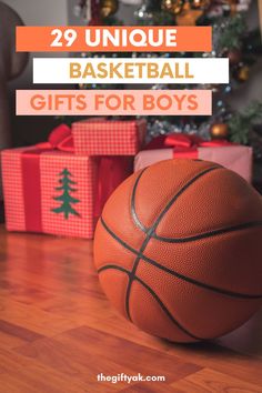 a basketball sitting on top of a hard wood floor next to presents under a christmas tree