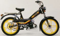 a black and yellow motorcycle parked next to a white wall