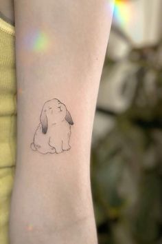 a small dog tattoo on the arm