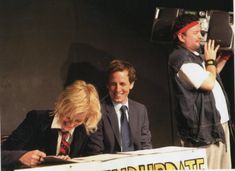 two men and a woman sitting at a table