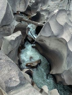 a river flowing through a rocky canyon filled with rocks and water in the middle of it