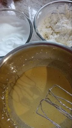 three bowls filled with food and whisks on top of a counter next to each other