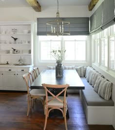 a dining room table and bench in front of a window