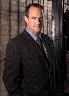 a man in a suit and tie standing next to a jail cell