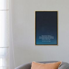 a living room with a gray couch and a framed poster on the wall above it