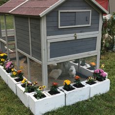 a chicken coop with flowers growing in it