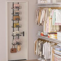 an organized closet with clothes and handbags hanging on the rack, next to a white door