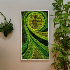 a green painting hanging on the wall next to a potted plant