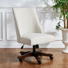 a white striped office chair next to a potted plant