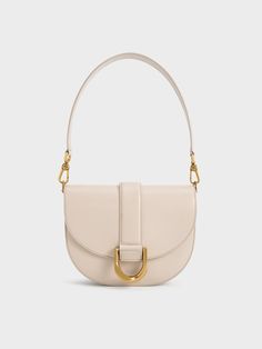 Update your Gabine collection with this oat-white leather version, exuding understated elegance and timeless luxury. Designed for the modern woman, the Gabine bag is perfect for both daytime outings and after-dark events. Its iconic design remains unchanged, from the U-shaped buckle to the classic saddle silhouette, along with the single handle, which can be swapped for a longer shoulder strap for hands-free convenience and versatile styling options. Gabine Saddle Bag, Charles And Keith, Leather Saddle Bags, Timeless Luxury, Charles Keith, Iconic Design, Understated Elegance, Saddle Bag, After Dark