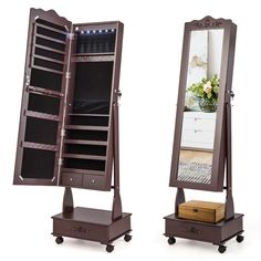 a wooden jewelry cabinet sitting on top of a table next to a mirror and drawer