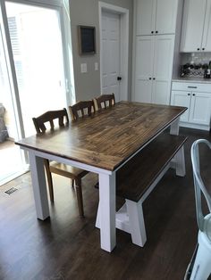 a large wooden table with chairs around it in a kitchen next to an open door