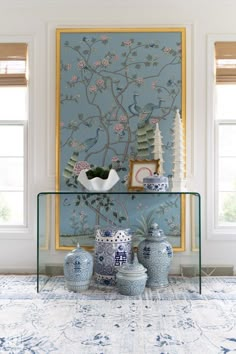 a blue and white room with vases on the table