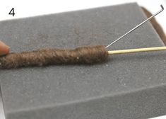 a needle is hooked up to a piece of wool