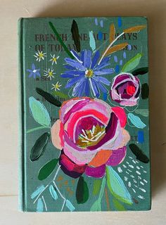 a book with flowers painted on the cover