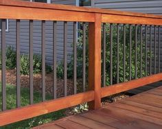 a close up of a wooden deck with metal railings on the side of a house