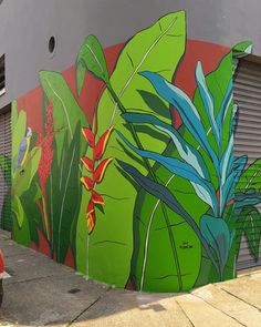 an orange scooter is parked in front of a colorful mural on the side of a building