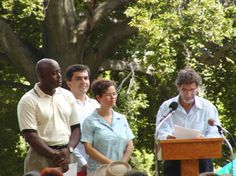 a group of people standing at a podium in front of a crowd with microphones