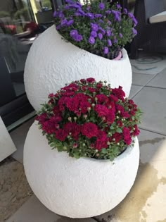 two large white vases with flowers in them