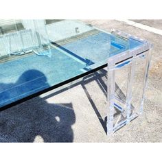 a clear glass table sitting on top of a sidewalk