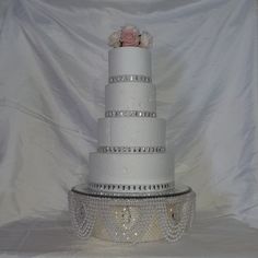 a three tiered wedding cake with flowers on top