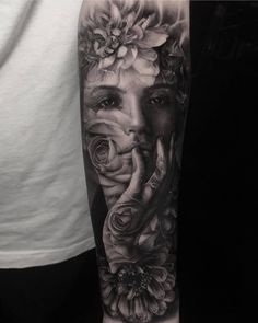 a woman's face with flowers on her arm