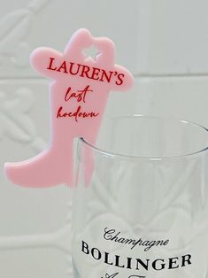 there is a glass with a pink boot on it and the word lauren's last name