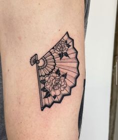 a black and white photo of an umbrella with flowers on the side of a woman's arm