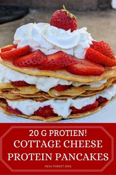 a stack of pancakes with strawberries on top and whipped cream on top, in front of the caption reads 20 g protein cottage cheese protein pancakes