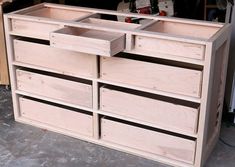 an unfinished dresser with drawers in the process of being assembled and put into place for storage