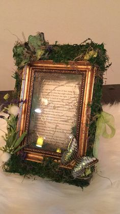 an ornate frame is adorned with greenery and candles